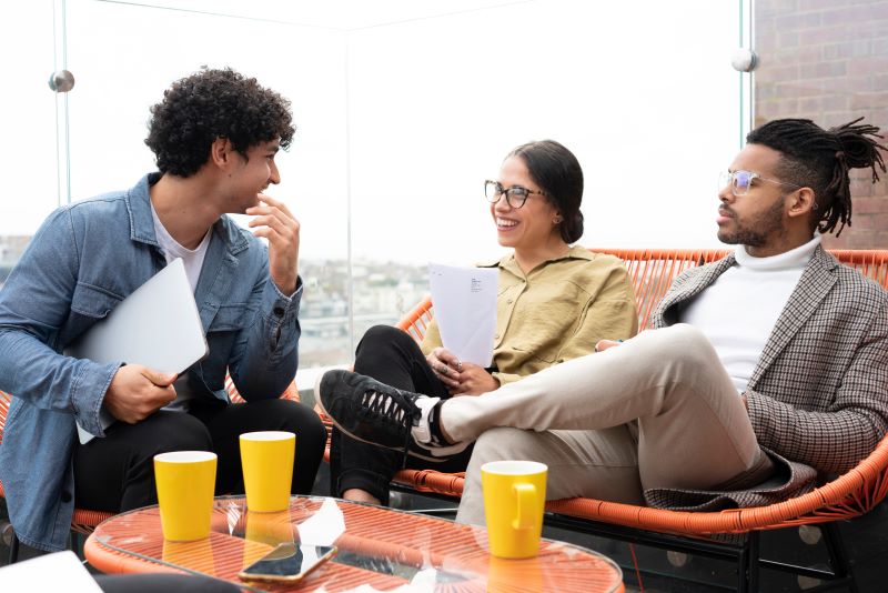 Três empreendedores de sucesso, que sabem o que é trabalho em equipe e qual sua importância, em uma reunião no terraço do escritório.