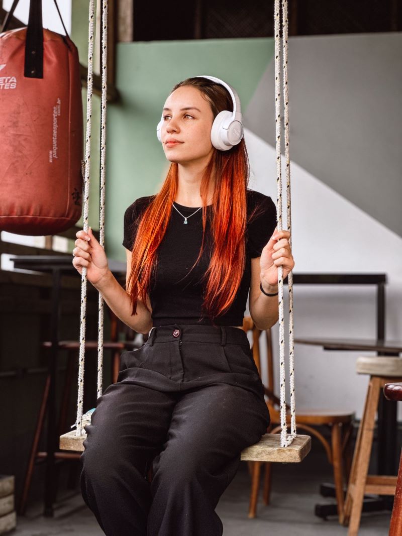 mulher sentada em balanço ouvindo música