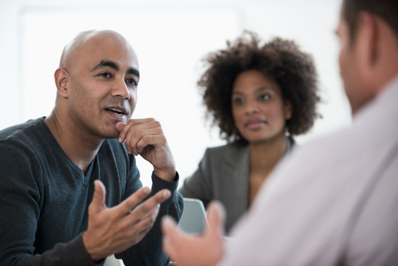 Comunicação interpessoal​: homens e mulher conversando no trabalho